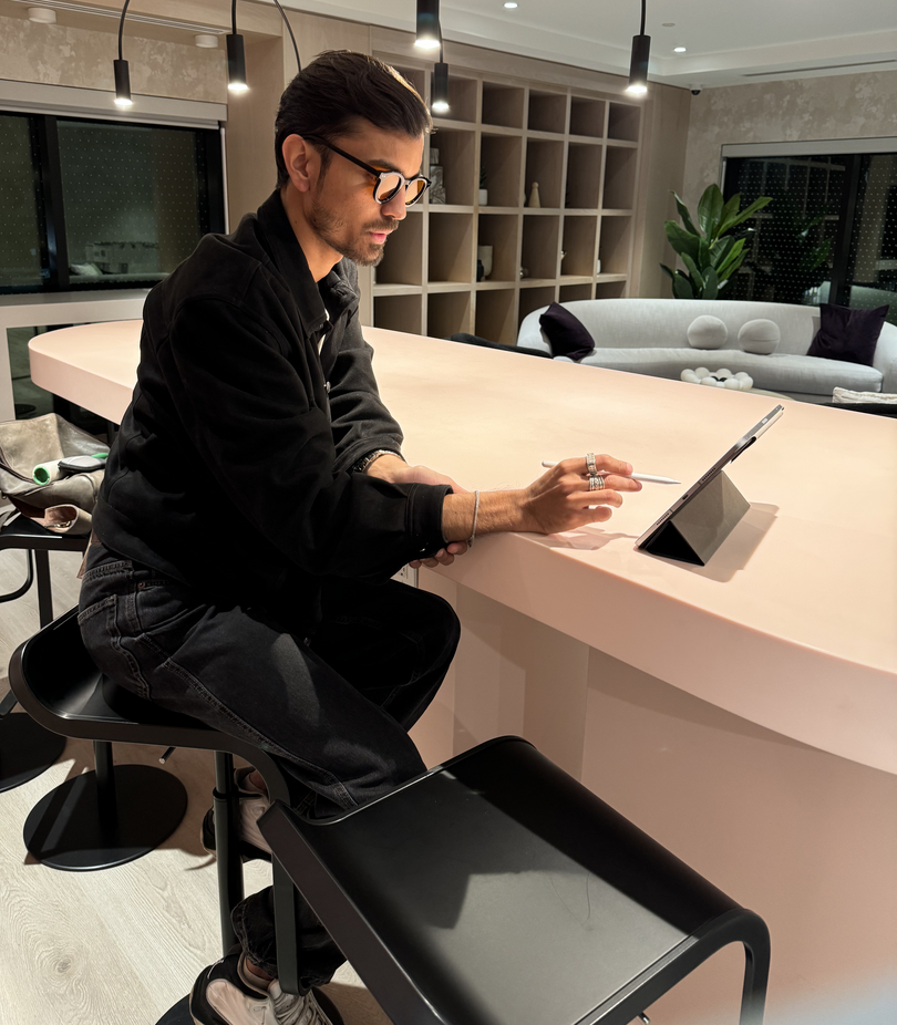 a man sitting at a table with his hand on his mouth